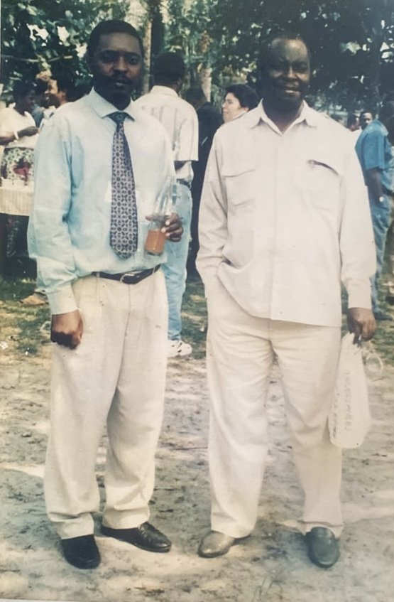 Deux délégués de la province posant à l'extérieur, l'un en chemise bleu clair et cravate, l'autre en tenue beige, lors d'une rencontre du réseau des ONG de développement